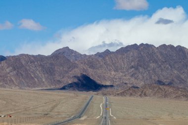 Çin 'in Qinghai eyaletinde dağlar ve otlaklar karayoluyla uzanır.