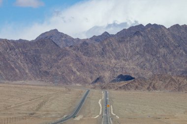 Çin 'in Qinghai eyaletinde dağlar ve otlaklar karayoluyla uzanır.