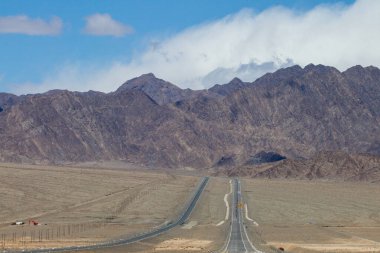 Çin 'in Qinghai eyaletinde dağlar ve otlaklar karayoluyla uzanır.