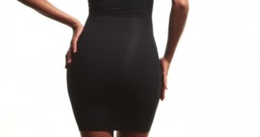 Dar, siyah elbiseli, eli kalçasında dans eden bir kadının orta kısmı.