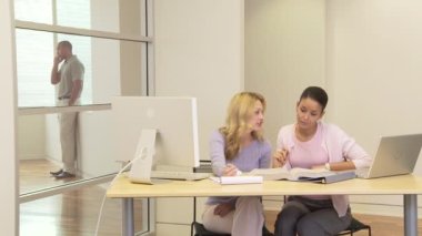 Ofiste bilgisayarla çalışan iki iş kadını