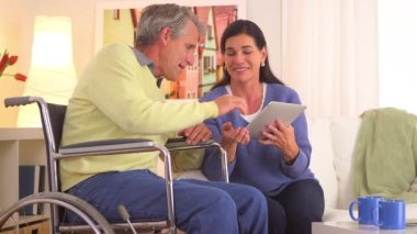 Yaşlı çift tabletle mutlu bir şekilde konuşuyor.