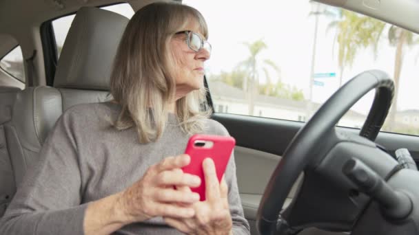 자동차를 스마트폰으로 확인하거나 메시지를 보내기도 나이든 여성은 운전하기 스마트폰을 — 비디오