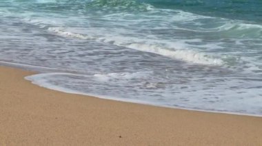 Küçük dalgalar yavaşça kıyıya vuruyor.