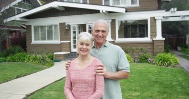 Önünde yeni ev gülümseyen kıdemli çift ayakta