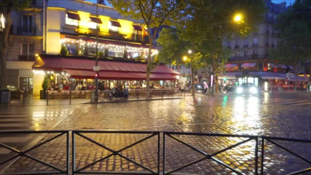 パリの都会の通りで雨の中車の交通を運転します 車で移動する忙しいヨーロッパの道と人々が歩く — ストック動画