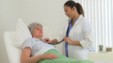 Kadın çok ırklı doktor hastasını muayene ediyor.