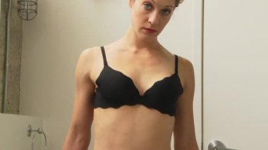 Evde iç çamaşırlı bir kadın.