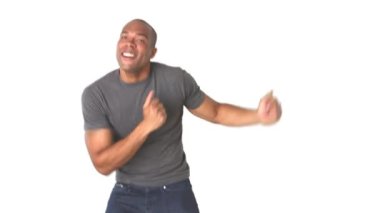 Kotlu ve tişörtlü genç adam dans ediyor.