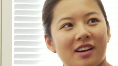 Asyalı genç iş kadını konuşuyor.