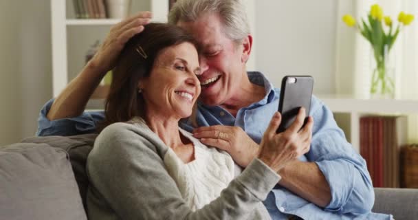 Dulce Pareja Ancianos Usando Teléfono Inteligente Sofá — Vídeos de Stock