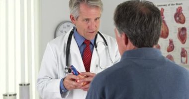 Kıdemli Doktor yaşlı hasta kalp açıklayan