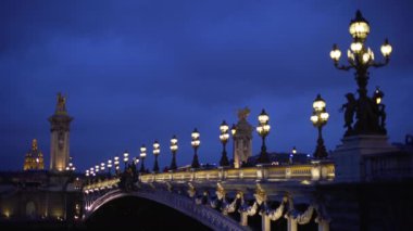 Paris 'te, Seine Nehri' nin karşısındaki Alexandre III köprüsünün romantik manzarası. Turistlerle aydınlatılmış Fransız köprüsü