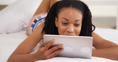 Mutlu siyah kadın yatakta tablet kullanma