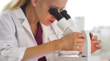 Mikroskop kullanan tıbbi araştırmacı.