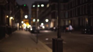 Londra 'da sessiz sakin bir caddenin bulanık görüntüsü, insanlar geceyi geçirdiler. Akşam geç saatlerde şehir sokağının odağını kaybetmiş, karanlık ve neredeyse boş. 4k
