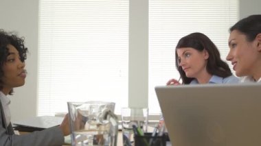 Dizüstü bilgisayarda birlikte çalışan bir grup iş kadını.