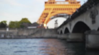 Paris 'teki Eyfel Kulesi ve Pont delena manzarası. Seine Nehri üzerindeki Fransız anıtı ve köprüsünün bulanık arkaplan görüntüsü