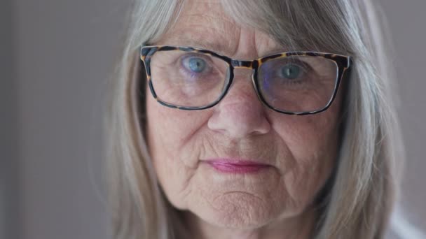 近照照片 照片上的高个子白种人女人戴着眼镜看着相机 看起来很伤心 退休的老年白人妇女的Ecu靠窗 慢动作4K — 图库视频影像