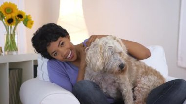 Afrikalı Amerikalı kadın kucağında köpekle poz veriyor.