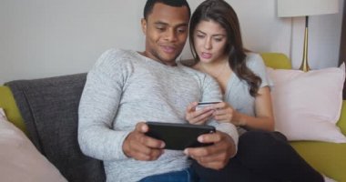 Milenyum çifti internette büyük bir alışveriş yapıyor. Çift kredi kartlarıyla pahalı biletler ayırtmak için cep telefonu kullanıyor. 4k ağır çekim el bilgisayarı