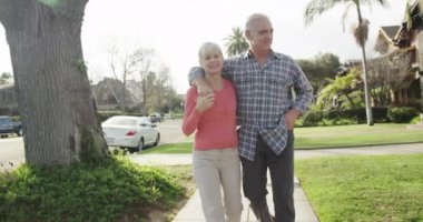 Tatlı yaşlı çift mahallede yürüyor.