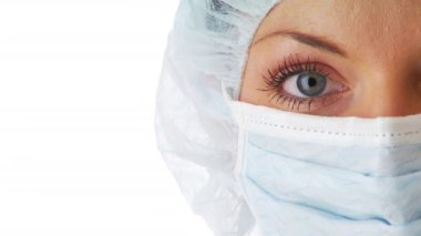 Doktor maskesi takan ve saç filesi takan genç bir kadın.