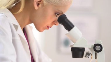Mikroskop kullanan tıbbi araştırmacı.