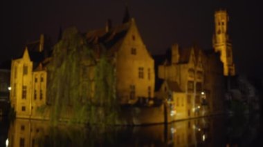 Bruges kanallarının arka plan plakası geceleri bulanık oluyor. Yeşil ekran bileşimi için bulanık dış gece video arkaplanı. 4k
