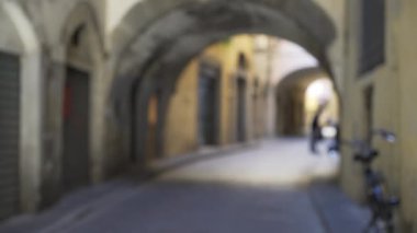 Dar yolun üzerindeki eski İtalyan kemeri. Boş bir sokakta kemerlerin bulanık arkaplan plakası