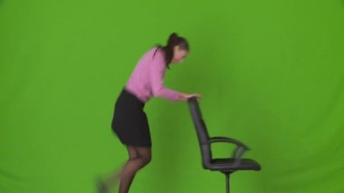Ofis sandalyesiyle dans eden genç iş kadını.