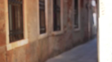 Eski Venedik binaları arasındaki dar geçitin odaksız arka plan plakası. Tarihi Venedik, İtalya 'da kaldırım taşı yolu olan bulanık bir sokak görüntüsü. 4k