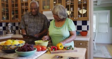 Üst düzey siyahi çift mutfakta birlikte yemek pişiriyor.