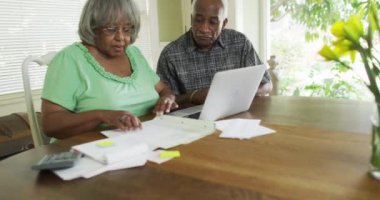 Bilgisayarda faturaları ödeyen yetişkin siyah bir çift.