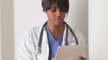 Tablet üzerinde çalışan Afrikalı kadın doktor.