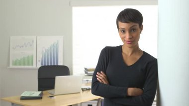 Afro-Amerikalı iş kadını kapıda gülümsüyor.