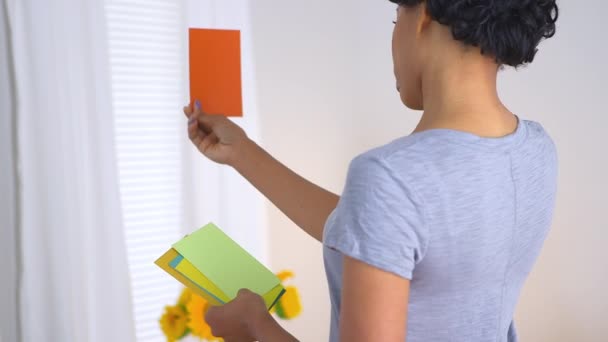 African American Woman Decidinf Which Color Paint Her Room — Stock Video