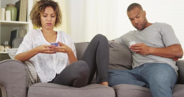 Black Couple Using Smartphones Couch — Stock Video
