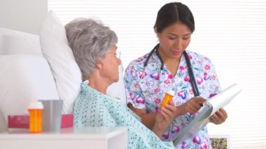 Japon hemşire yetişkin bir hastaya ilacı açıklıyor.