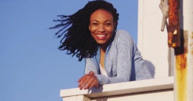 Mutlu Afrikalı kadın raylara yaslanmış gülüyor