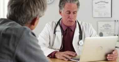 Doktor ve kıdemli hasta masada konuşurken