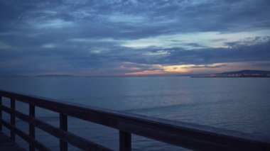 Seal Beach rıhtımında gün batımında yeşil ekran veya kroma anahtarı için ön planda tırabzan var. Birleşiklik ya da anahtarlama için odak dışı ya da odaksız çekim. 4k