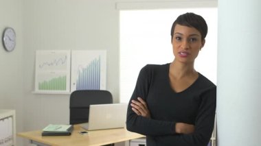 Afro-Amerikalı iş kadını kapıda dikilip konuşuyor.