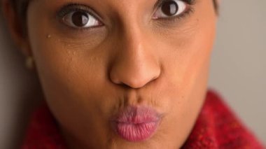 Afro-Amerikalı kadın surat yapıyor ve gülümsüyor