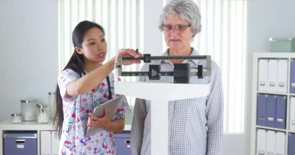 Enfermera China Que Pesa Paciente Anciano — Vídeo de stock