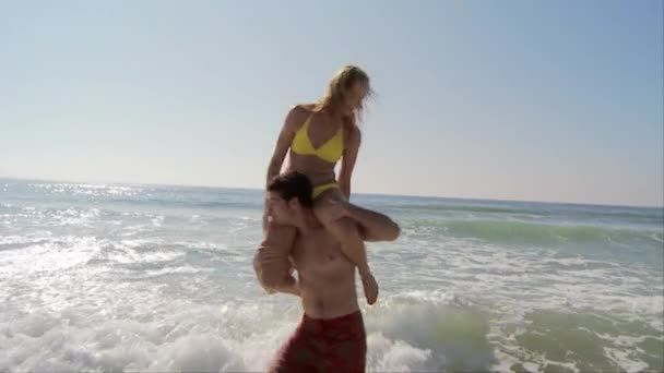 Jovem Casal Praia Dando Porquinho Volta Passeios Caindo Oceano — Vídeo de Stock