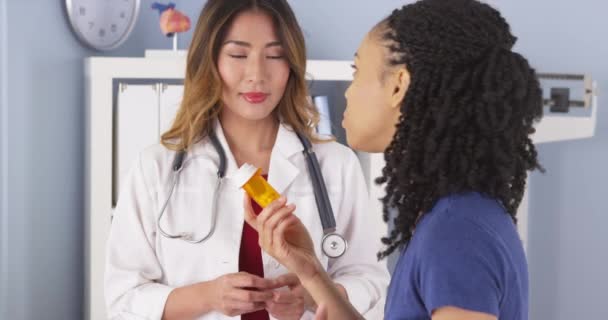 Médico Japonés Explicando Nueva Prescripción Paciente Negro — Vídeos de Stock