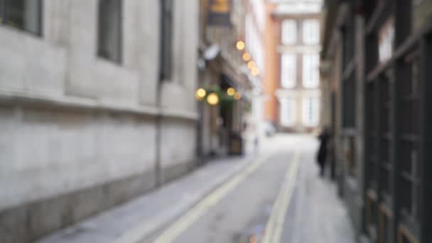イングランド ロンドンの静かな裏通りの遅い水平パン 歩行者の背景に残るロンドンの路地のぼやけたショット — ストック動画