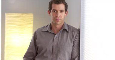 Kameraya bakarak duvara yaslanmış işadamı