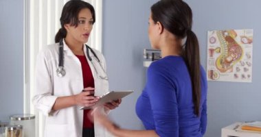 İspanyol Afro-Amerikan hastaya tablet ile konuşurken Obgyn